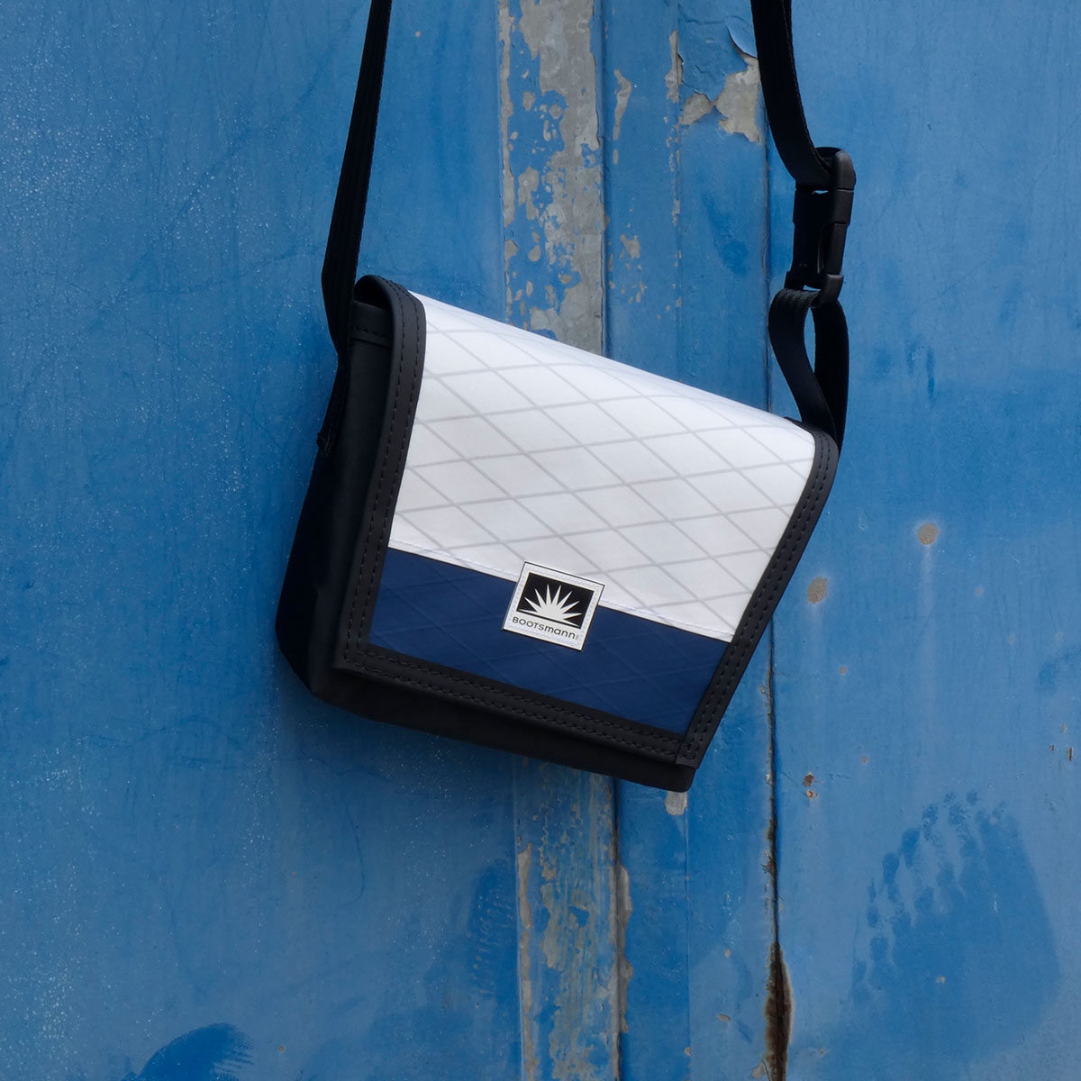 asche Bootsmann XS hängt an alter Metalltür – handgefertigte Umhängetasche aus X-PAC und Masttaschentuch, wetterfest und langlebig