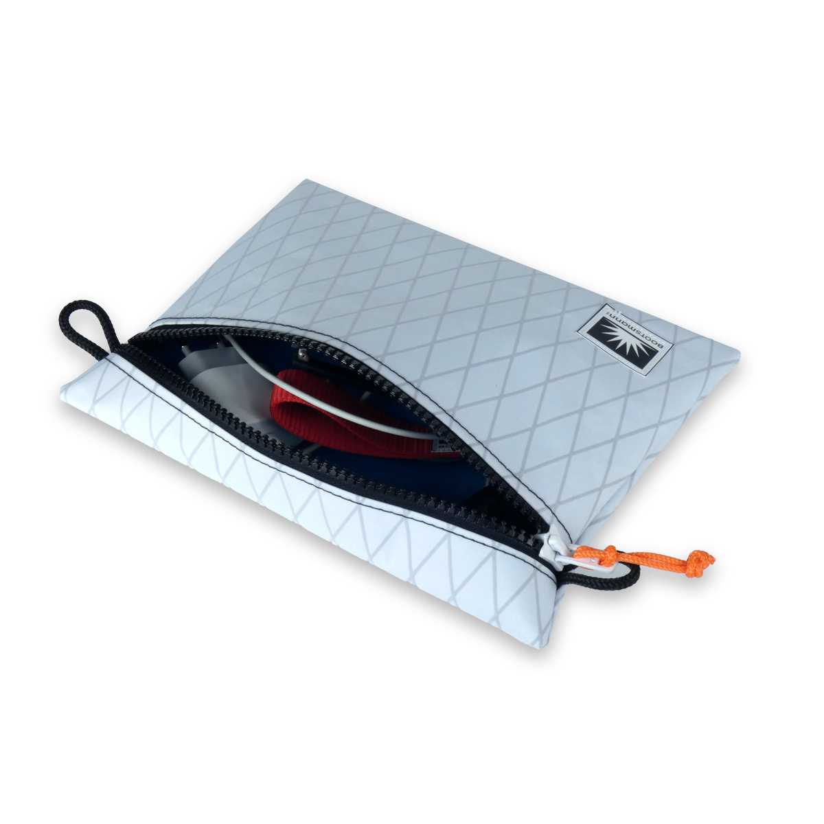 Geöffneter Bootsmann Beutel aus X-Pac, freigestellt – mit sichtbarem Inhalt wie Ladekabel, Sonnenbrille und Alltagszubehör.