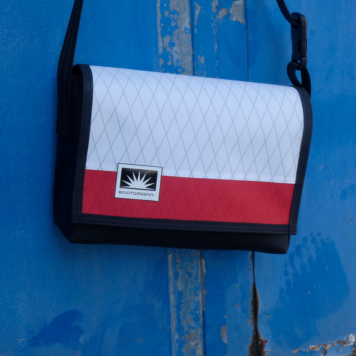 M-Tasche aus X-Pac und Masttaschentuch hängt an rostiger Metalltür