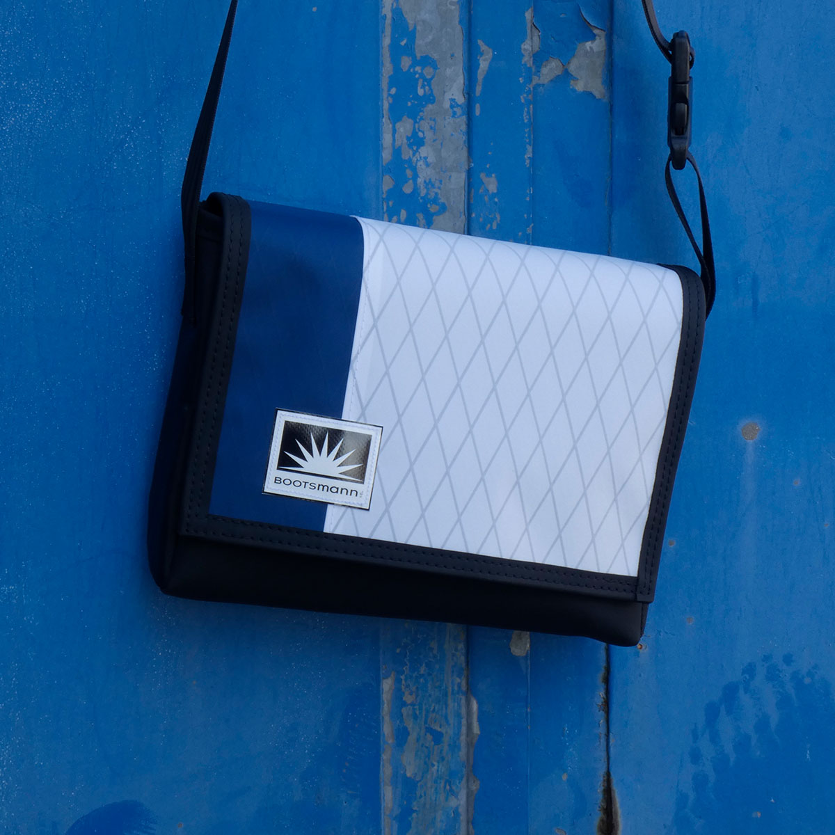 S-Quer Umhängetasche von Bootsmann aus X-Pac und Masttaschentuch, hängend an einer rostigen Metalltür