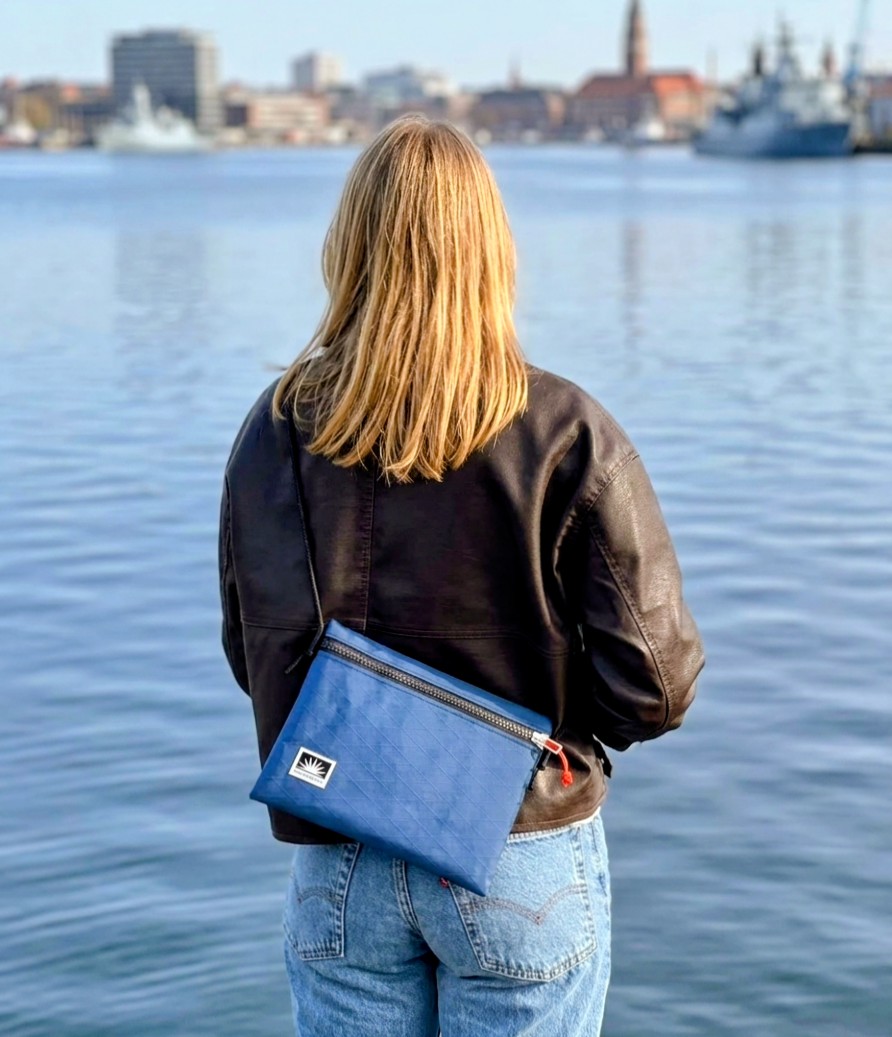 Junge Frau trägt eine Bootsmann Slingbag aus X-Pac über der Schulter