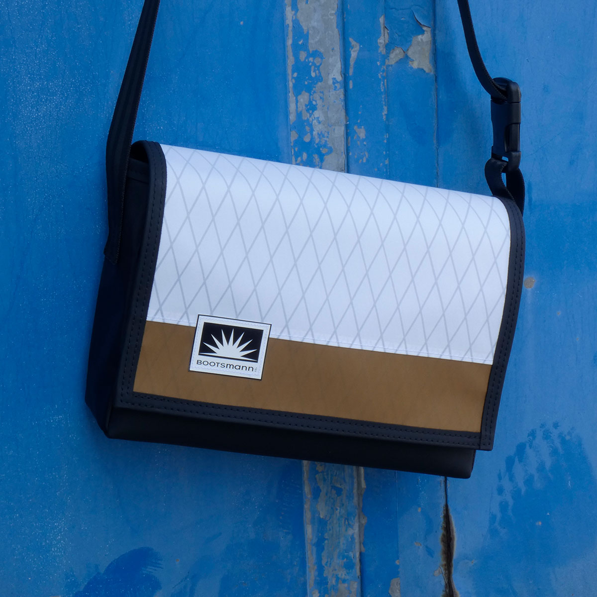 M-Tasche aus X-Pac und Masttaschentuch hängt an rostiger Metalltür