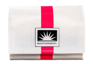 Weiße Geldbörse aus Segeltuch mit einem auffälligen Streifen in Pink. Freigestellt vor weißem Hintergrund.“