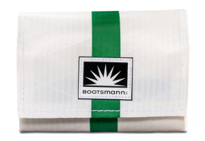 Weiße Geldbörse aus Segeltuch mit einem auffälligen Streifen in Grün. Freigestellt vor weißem Hintergrund