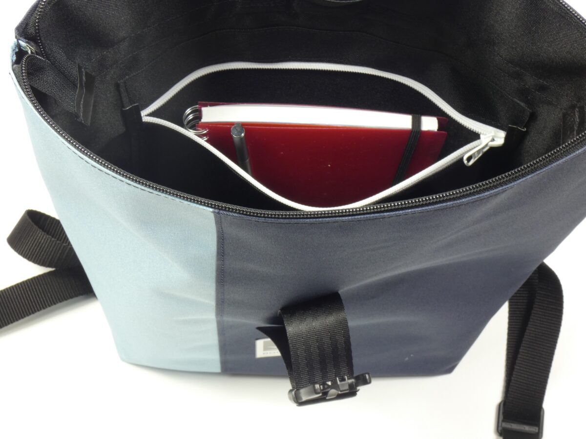 Großer BOOTSMANN-Rucksack aus Canvas in Hellblau und Navyblau, geöffnet gezeigt, mit Blick auf die Reißverschluss-Innentasche, freigestellt