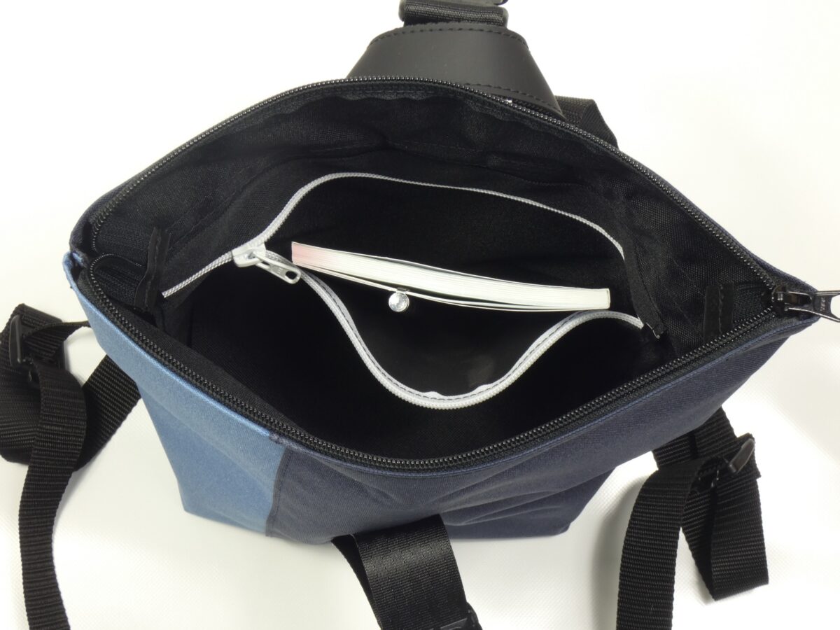 BOOTSMANN-Rucksack aus Canvas in Jeansblau und Navyblau, Größe S, geöffnet gezeigt, mit Blick auf die Reißverschluss-Innentasche, freigestellt