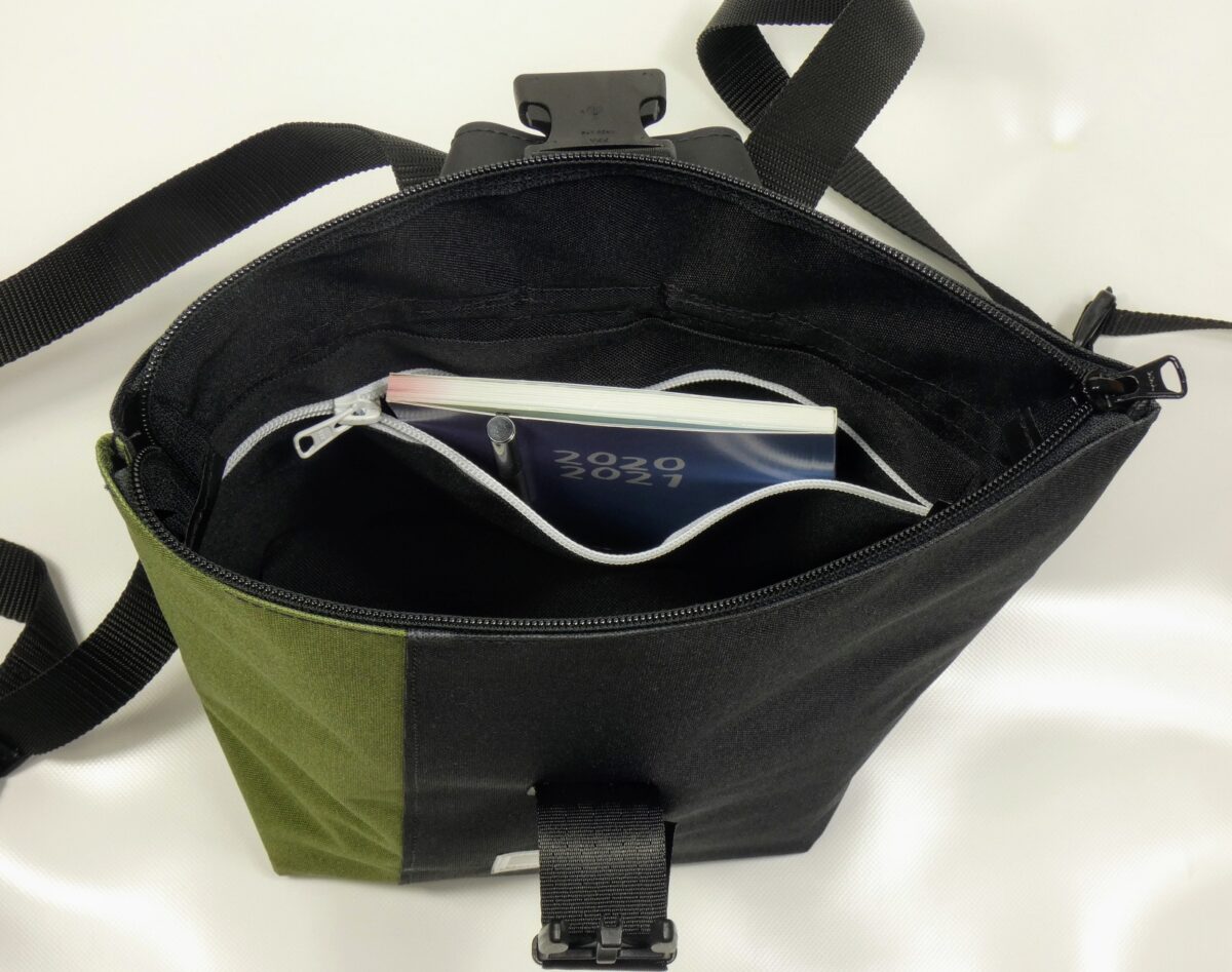 BOOTSMANN-Rucksack aus Canvas in Oliv und Schwarz, Größe S, geöffnet gezeigt, mit Blick auf die Reißverschluss-Innentasche, freigestellt