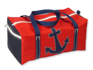Sporttasche aus Canvas in Größe M. Freigestellt vor weißem Hintergrund. Die Tasche ist rot, der Gurt dunkelblau, auf der Vorderseite ist ein blauer Anker abgebildet