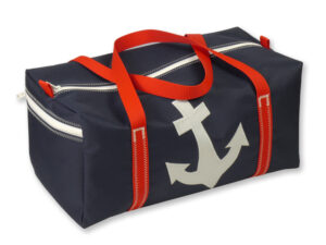 Sporttasche aus Canvas in Größe M. Freigestellt vor weißem Hintergrund. Die Tasche ist navydunkelblau, der Gurt rot, auf der Vorderseite ist ein weisser Anker abgebildet