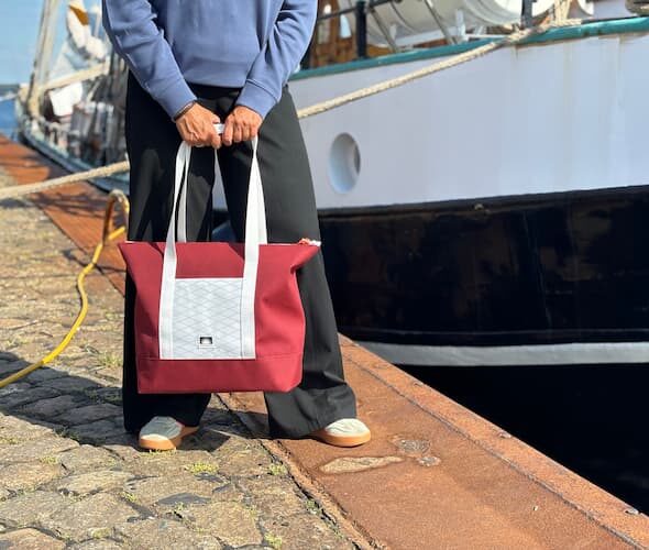 Handgemachte Shopper Tote Bag aus Persenningtuch am Tiessenkai, im Hintergrund ein Traditionsschiff