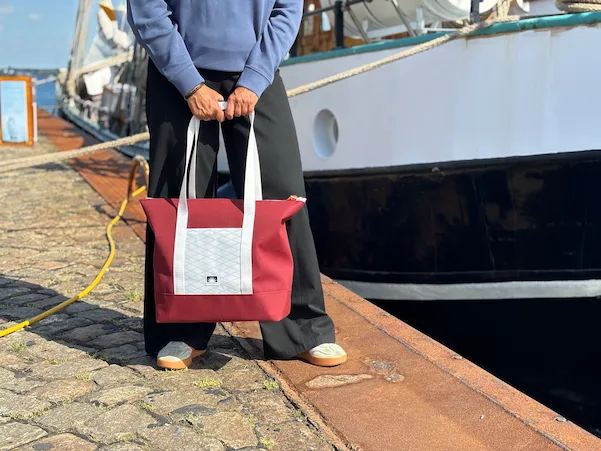 Handgemachte Shopper Tote Bag aus Persenningtuch am Tiessenkai, im Hintergrund ein Traditionsschiff