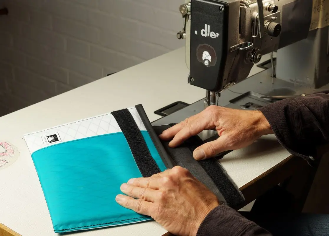 Handgefertigte iPad-Tasche aus X-Pac wird in der Bootsmann Kiel Manufaktur am Tiessenkai an einer Industrienähmaschine gefertigt.
