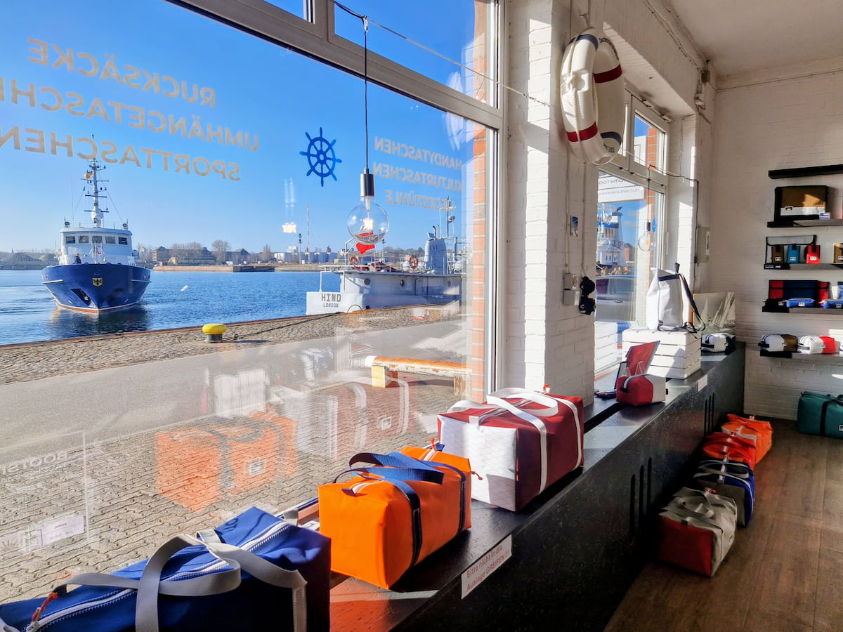 Blick durch das Ladengeschäft am Tiessenkai auf Hafen und Schiffe